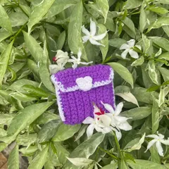 Another view of the purple coin pouch, showing how it looks against different flowers. You can pick any two colors for your own custom pouch.