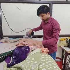 Pressing and ironing are critical steps in the tailoring process. Here, a member of my team is carefully ironing a garment to set the seams and give it a crisp, professional finish before it's ready for delivery.