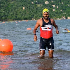 An athlete emerging from the water during the swim leg of a triathlon. We prepare our swimmers for real-world open water conditions, so they feel confident and ready on race day.