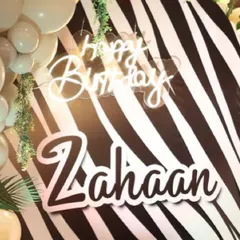 A close-up of the personalized "Happy Birthday Zahaan" neon sign against a zebra-print backdrop, showing how I customize every detail for the birthday boy.