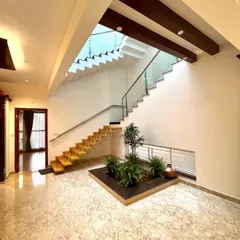 The interior of Mr. Vinay's residence features a central courtyard under a skylight. The floating staircase with its glass railing allows light to pass through, keeping the space bright and open.