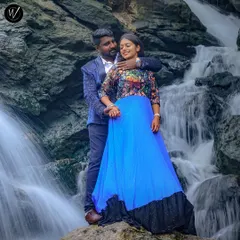 An example of our outfits in a natural setting, this couple is posed against a waterfall. The man's patterned blue blazer perfectly complements the woman's vibrant blue gown with its floral bodice.