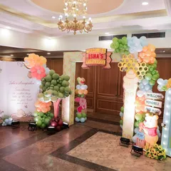 The entrance to the Winnie the Pooh celebration, with a custom 'Isha's Inauguration' sign and a large, illuminated photo frame for a personal touch.