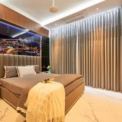 In this bedroom, we blended multiple textures for a rich, sophisticated feel. The design features a tufted headboard, a backlit art piece, and a stunning floor-to-ceiling backlit onyx marble panel that serves as a unique, glowing feature wall.