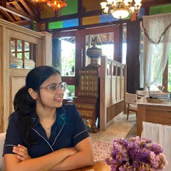 Enjoying a quiet moment in a cafe in Chiang Mai, surrounded by beautiful wooden interiors and colorful stained glass. The atmosphere of a place, its textures, and its use of light are all things I draw upon for home decor inspiration.