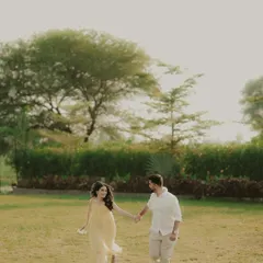 A classic romantic shot of a couple walking hand-in-hand through a park. This image captures a simple, happy moment that feels natural and unposed.