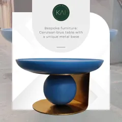 A unique sculptural side table in a vibrant cerulean blue, set on a distinctive brass metal base. This piece is functional art, designed to add a pop of color and modern flair to any interior.