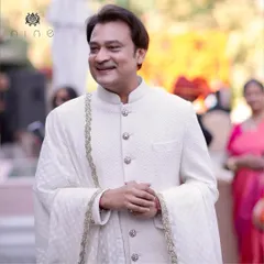A proud groom, Saket Modi, looking dashing and regal in his bespoke ivory sherwani. We crafted this piece with a textured fabric and custom jeweled buttons to be as special as his big day.
