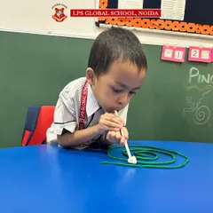 A student concentrates on our Ping Pong Play Dough Straw Maze activity. This play-based exercise is designed to strengthen hand-eye coordination and fine motor skills in a fun, engaging way.