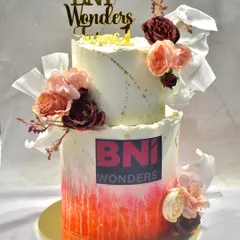 Celebrating a corporate milestone with a two-tiered cake for BNI Wonders' first anniversary. This custom cake featured layers of chocolate and fresh strawberry, decorated with their logo.