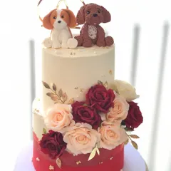 A beautiful two-tiered engagement cake that includes the couple's fur babies. The handcrafted dog toppers add a wonderfully personal touch.