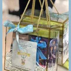 Here are the hot air balloon return favors packed in transparent handle boxes. The polka dot ribbon and custom card tie the whole dreamy theme together beautifully.