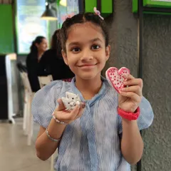 A young participant proudly shows off her handmade clay cat and heart. Our workshops are a great way for kids and adults to spend a weekend.