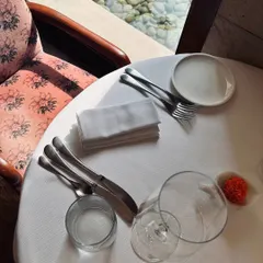 A quiet moment during lunch service at Indian Accent. The natural light, crisp white tablecloth, and elegant glassware create a serene and sophisticated atmosphere for a midday meal.
