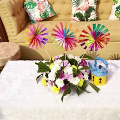 Even the seating areas get a touch of personality. We created this cozy corner with fun, tropical-print cushions and a centerpiece featuring colorful pinwheels and a quirky painted kettle, perfect for a relaxed Mehendi vibe.