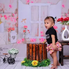 A candid shot filled with expression. The baby's open-mouthed look of wonder or excitement brings so much personality to this photo from the floral-themed session.