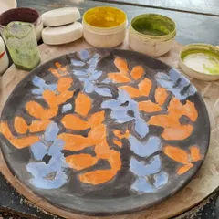 The first layer of color is applied. This plate is being prepared for sgraffito, where I will carve away parts of the black slip to reveal the design.