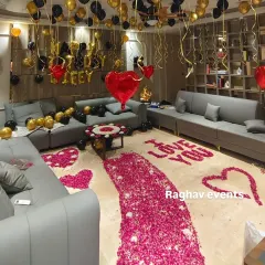 I can turn any room into a romantic surprise for your wife's birthday. This decoration features a pathway of rose petals leading to a cozy setup with 'Happy Birthday Wifey' foil balloons, and a mix of black and gold balloons for a classy look.