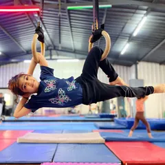 This little champ is swinging her way to greatness. Her joyful expression says it all: hard work is fun when you're learning to fly on the gymnastic rings.