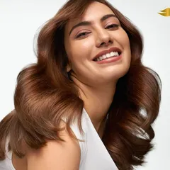 A clean, luminous studio photograph for a Dove haircare campaign. This image captures a model with healthy, voluminous brown hair and a joyful expression, highlighting the product's ability to create shine and vitality. The bright, high-key lighting is characteristic of my advertising work for major FMCG brands.