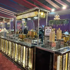 To bring the authentic taste of home-style cooking to your event, I set up a 'Desi Rasoi' station. This counter features traditional Indian dishes prepared live, served from classic brass pots on an elegantly designed stall.