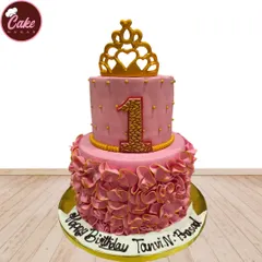 Perfect for a first birthday, this two-tiered pink princess cake is decorated with a golden crown and elegant ruffles. The textured number '1' adds a special touch for the big milestone.