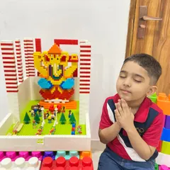 A young boy offers a prayer to a beautifully constructed LEGO Ganesha idol placed in a miniature pandal. This moment captures the wonderful blend of devotion, play, and creativity that our workshops inspire.
