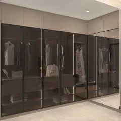 For the ultimate in organization and style, we designed this walk-in closet with smoked glass doors and integrated lighting. The layout provides a clear view of the contents while maintaining a sleek, high-end look.
