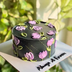 A love story as timeless as this palette knife floral beauty. This anniversary cake features a dramatic black base with purple and green palette-knife flowers for a modern, artistic statement.