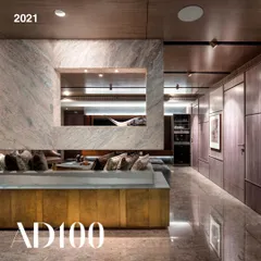 The living area of the Jain Residence, an AD100 project from 2021. The design uses a massive block of marble to frame the space, with a custom brass-clad console adding warmth and texture.