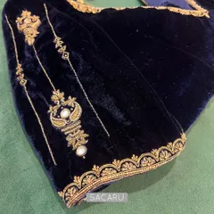 A sapphire blue velvet blouse with gold embroidery is a timeless wardrobe staple. This piece features delicate motifs on the sleeves, perfect for pairing with silk sarees.