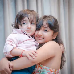 A big sister wraps her arms around her little brother. We focus on capturing this natural affection in our sibling photoshoots.