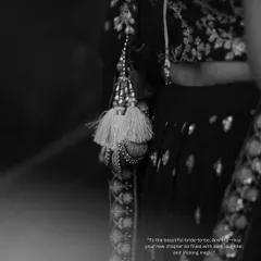 A detailed black and white shot focusing on the beautiful tassels of the bride's lehenga. I believe in capturing these small, artistic details that complete the story.
