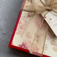 A close-up of the exquisite gift wrapping for our Raksha Bandhan hampers. The floral paper, delicate ribbon, and personalized tag set the stage for the beautiful gift inside.