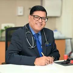 A warm and professional headshot for a doctor at his desk. This type of environmental portrait helps build trust and makes a medical professional feel more approachable to potential patients.
