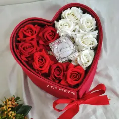 The top tier of the heart box is filled with beautiful red and white roses and a ring box.