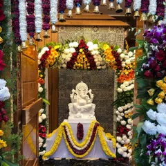 A beautiful moment from the housewarming ceremony at the "Sanman" residence, with the Ganesha idol placed in the elegantly designed pooja room. This space features custom tile work and a traditional bell arrangement.