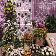 A lush corner filled with a variety of colorful flowers in wicker baskets, adding texture and life to the event space.