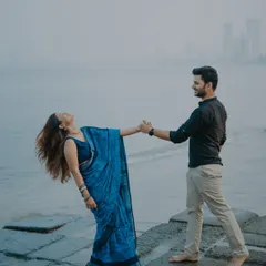 A candid moment of connection by the sea, with the Mumbai skyline in the distance. My focus is on capturing the natural movement and emotion between a couple, creating dynamic and heartfelt seaside romance photos.