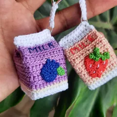 A pair of my flavored milk keychains, featuring blueberry and strawberry designs. The tiny embroidered fruit and "milk" lettering make these some of my most detailed charms.