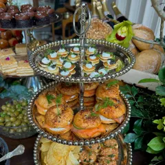 Our catering service includes a wide array of gourmet canapés. This three-tiered stand from a luxury brunch features smoked salmon bagels, tuna bites, and caviar blinis, perfect for high-end celebrations.