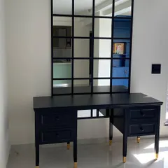 A custom-made black study or dressing table with elegant turned legs and brass-capped feet. Paired with a windowpane mirror, it creates a chic and functional workspace.
