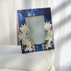 A bold and artistic choice, this frame features a deep blue marbled effect, adorned with three-dimensional silver-plated flowers.
