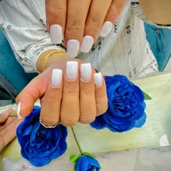 A beautiful set of milky white nails on medium-length square extensions. This is a chic and versatile look that is always in style.