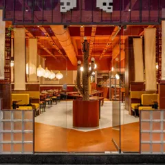 **Tres Amigos Restaurant, Ahmedabad:** This entrance shot captures the immersive cultural experience we designed for this Mexican restaurant. The vibrant color palette, custom lighting, and central cactus sculpture immediately set a warm, inviting tone, showcasing our ability to translate a brand's essence into a physical space.