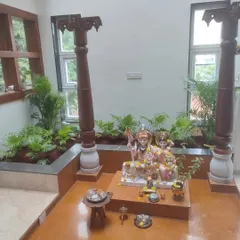 Another angle of the serene indoor garden setup, highlighting the traditional wooden pillars and the lush greenery that fills the space with positive energy.