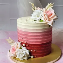 Pretty as a picture. This cake features a beautiful red ombre buttercream texture, decorated with fresh roses for a classic and romantic look.