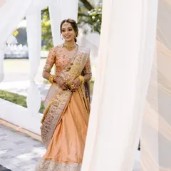 Bathed in blessings and glowing with happiness. This bride looks stunning for her Haldi ceremony in a peach and gold half saree, her makeup kept fresh and radiant.