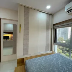 This view highlights the sleek, space-saving sliding wardrobe and the large window that fills the room with natural light.