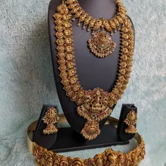 A complete muhurtham look featuring a Kaasu-inspired haaram and a peacock motif choker. The set is completed with a traditional Laxmi hip belt, offering a cohesive and divine bridal style.